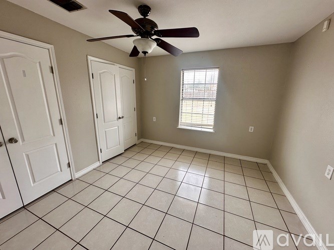 A room with a ceiling fan and tile flooring.