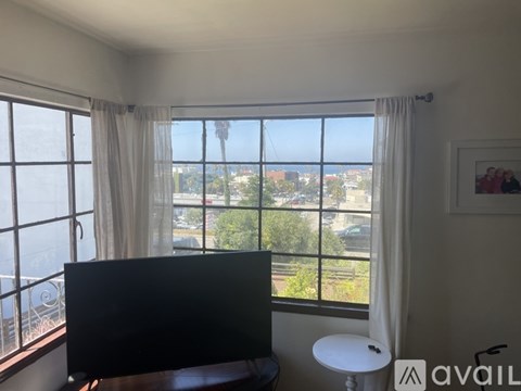 A living room with a flat screen TV and a view of the city.