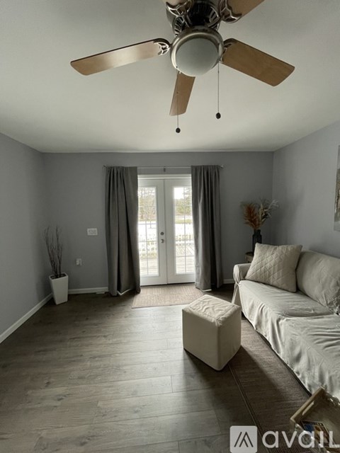 A living room with a white couch and a ceiling fan.
