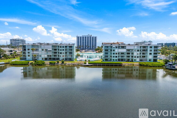 A large body of water in front of apartment buildings with a clear blue sky.