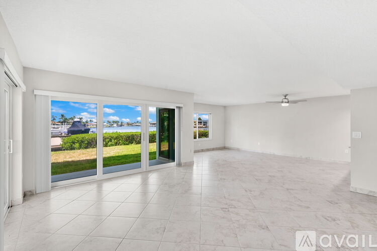 A spacious room with tiled flooring and a view of the outdoors through large windows.