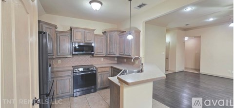 A kitchen with a black stove top oven and a black refrigerator.