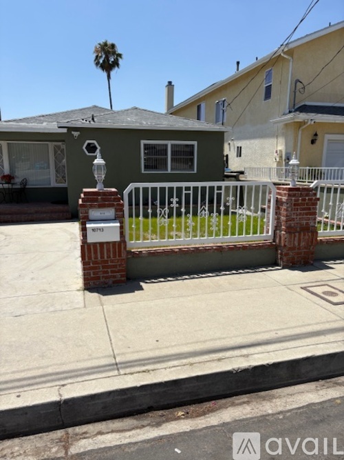 A house with a white fence and a mailbox on the left.