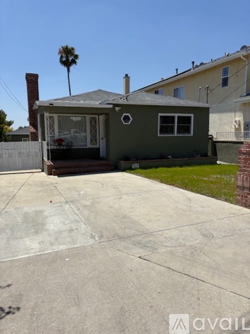 A house with a patio and a palm tree in the background.