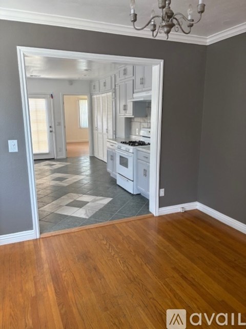 A kitchen with white cabinets and a checkered floor.