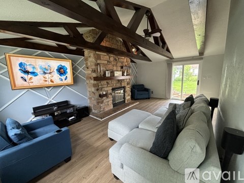 A living room with a blue couch and a painting on the wall.