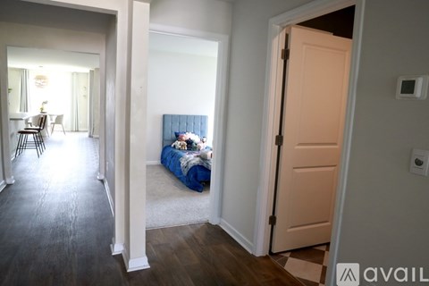 A bedroom with a bed and a door leading to another room.