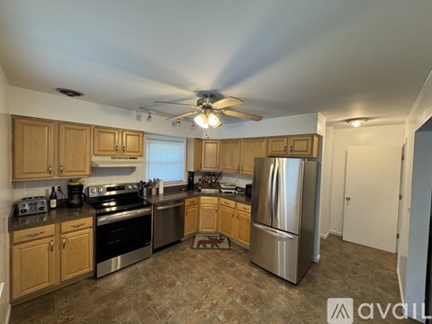 A kitchen with wooden cabinets and a stainless steel refrigerator.