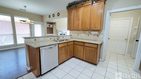 A kitchen with wooden cabinets and a white dishwasher.