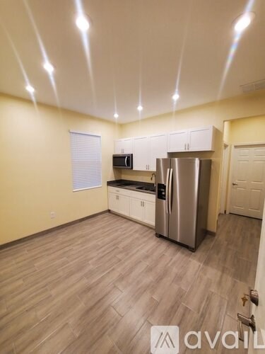A kitchen with wooden floors and stainless steel appliances.