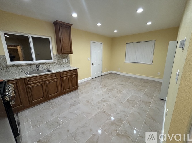 A kitchen with a granite countertop and wooden cabinets.