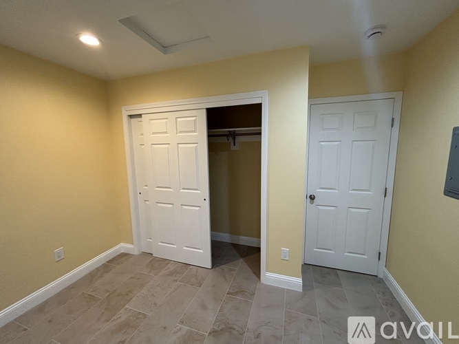 A room with a white door and a tiled floor.