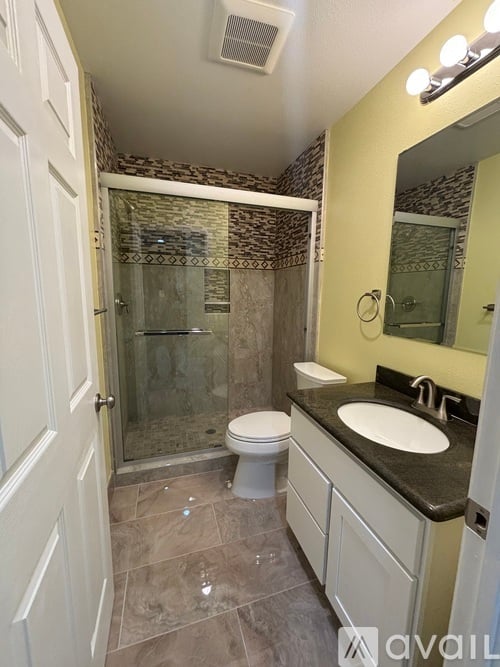 A bathroom with a toilet, sink, and shower.