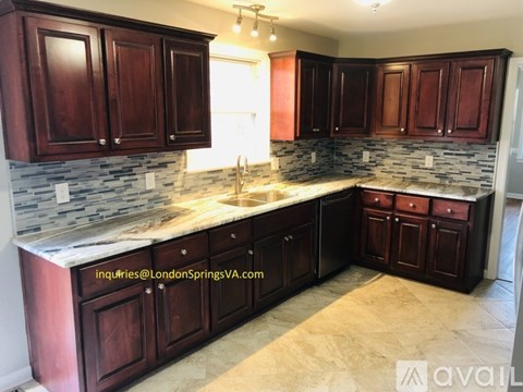 A kitchen with dark wood cabinets and a stone backsplash.