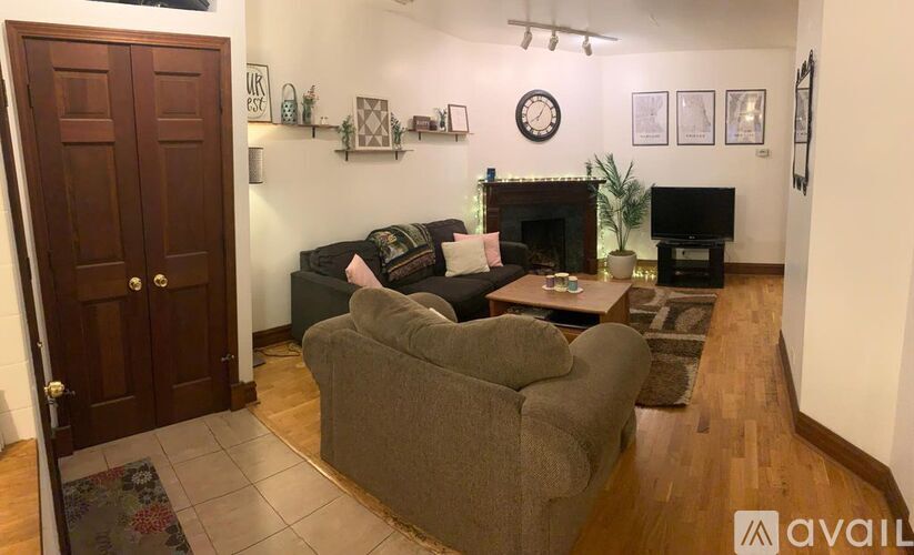 A living room with a grey couch and a fireplace.