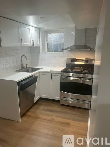 A kitchen with white cabinets and a stainless steel oven.