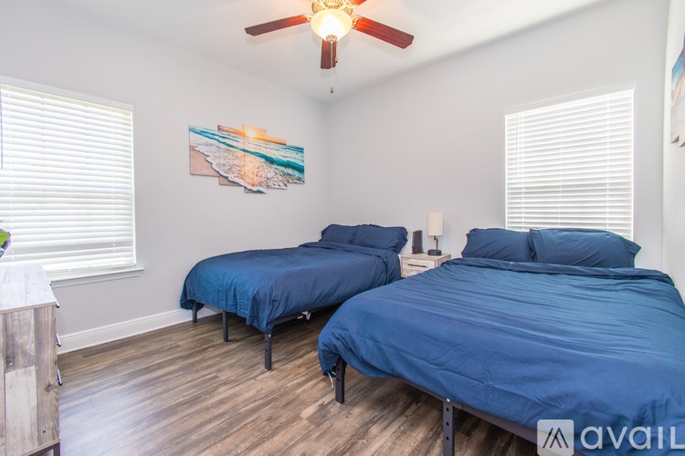 A bedroom with two beds and a ceiling fan.