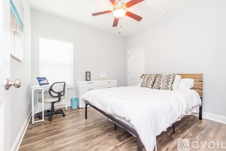 A bedroom with a bed, desk, and chair.