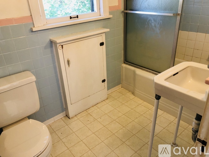 A bathroom with a toilet, sink, and shower.