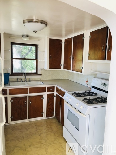 A kitchen with white appliances and wooden cabinets.