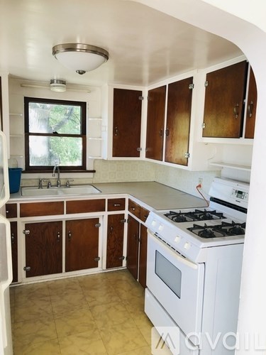 A kitchen with white appliances and wooden cabinets.