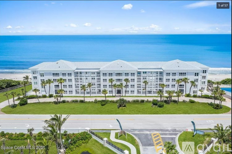 A large white building with a palm tree in front of it.
