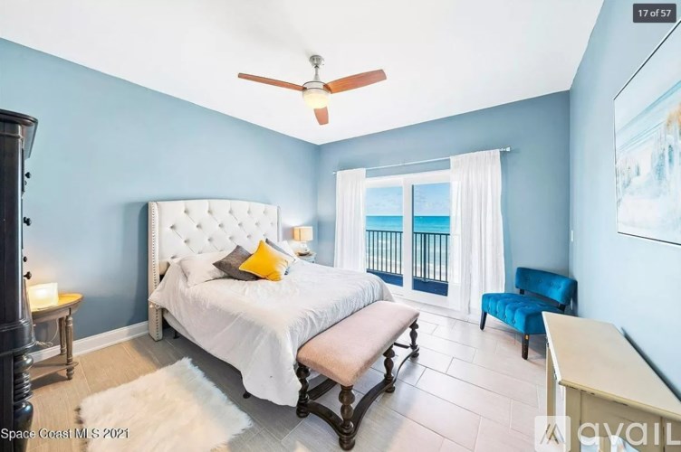 A bedroom with a bed, chair, and a painting on the wall.