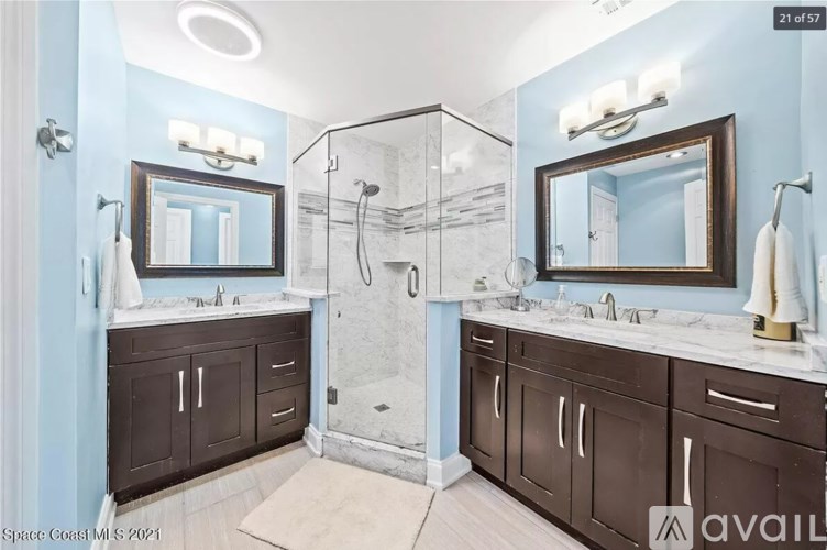 A bathroom with two sinks and a shower.
