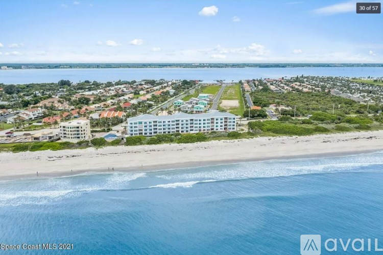A beachfront property with a large building and a swimming pool is for sale.
