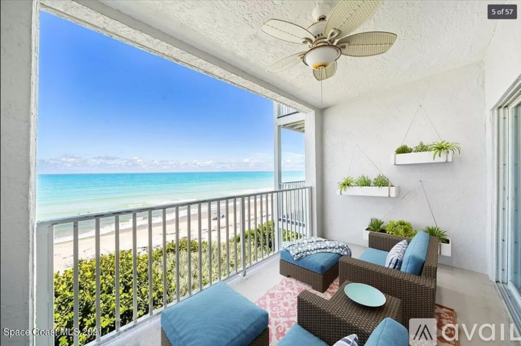 A balcony with a view of the beach and ocean.