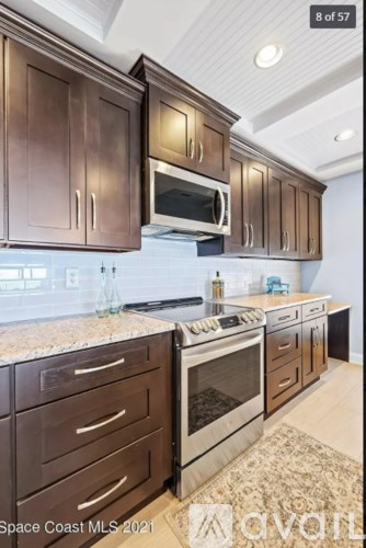 A kitchen with brown cabinets and a granite countertop.