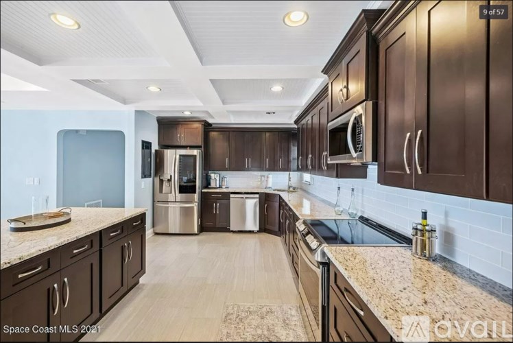 A kitchen with brown cabinets and a marble countertop.