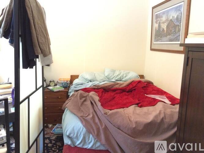 A bed with a red blanket on it in a room.