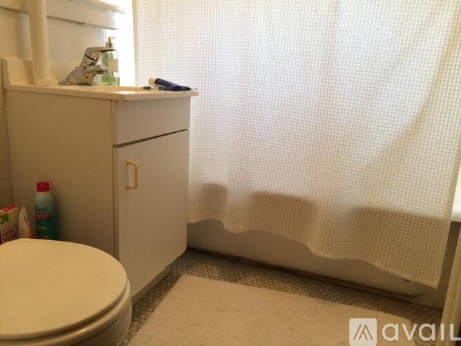 A white bathroom with a toilet, sink, and shower curtain.