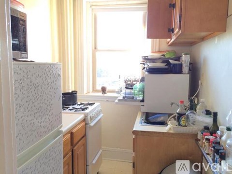 A kitchen with a white fridge, white stove, and wooden cabinets.