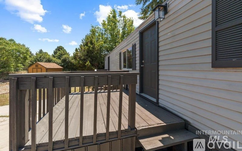 A wooden deck with a railing is in front of a house.