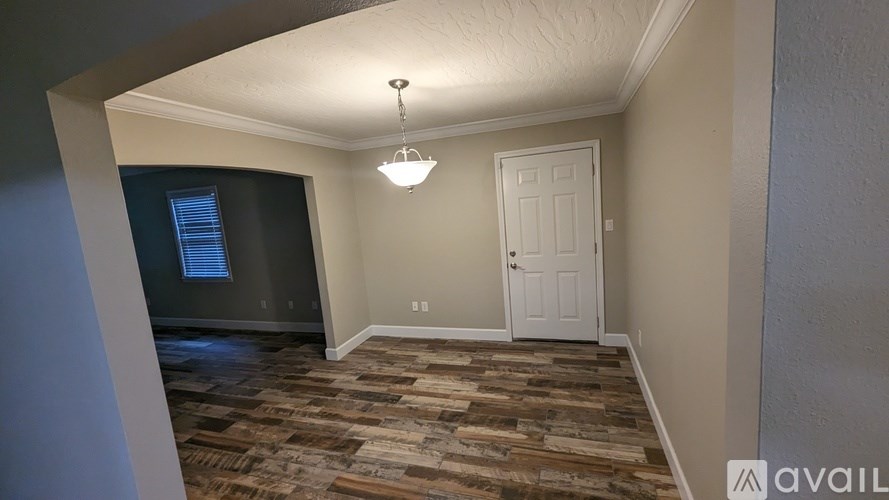 A room with a wooden floor and a white door.