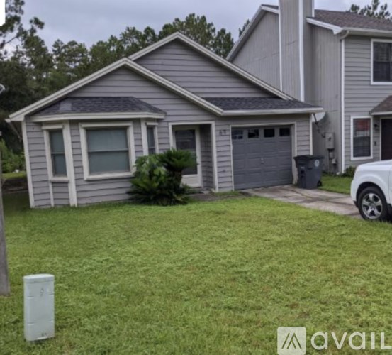 A house with a grey roof and a white car parked in front.