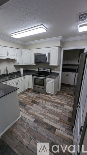 A kitchen with a refrigerator, oven, and microwave.