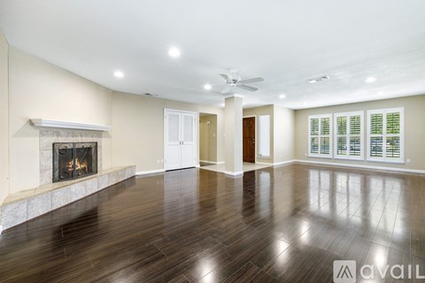 A spacious living room with a fireplace and hardwood floors.