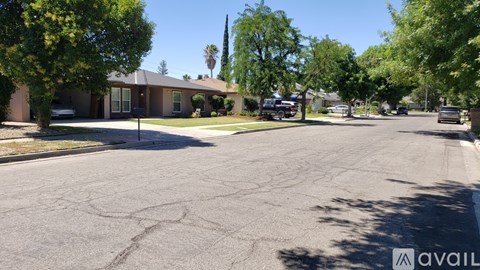A street view of a residential area with houses and trees.