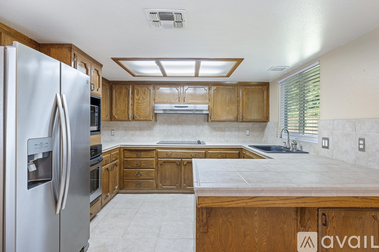 A kitchen with wooden cabinets and a refrigerator.