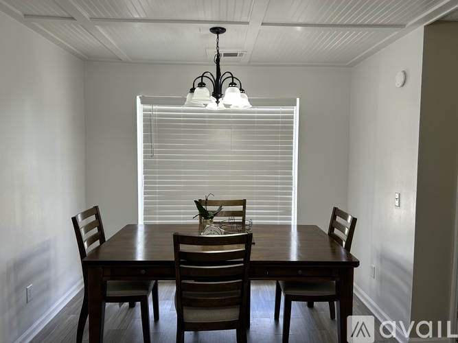 A dining room with a wooden table and chairs.