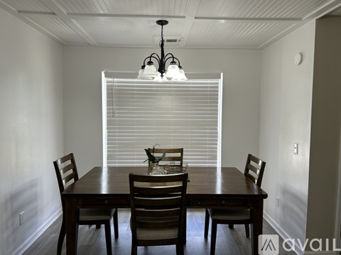 A dining room with a wooden table and chairs.