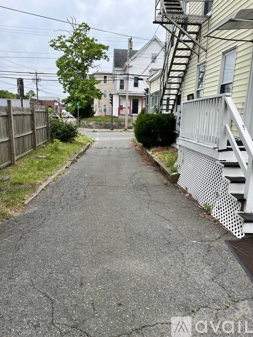 A residential street with houses on both sides and a fire escape on the right.