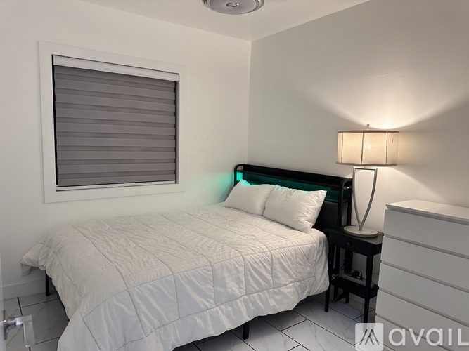 A bedroom with a bed, nightstand, and lamp.