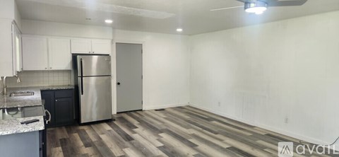 A kitchen with a refrigerator and a sink.