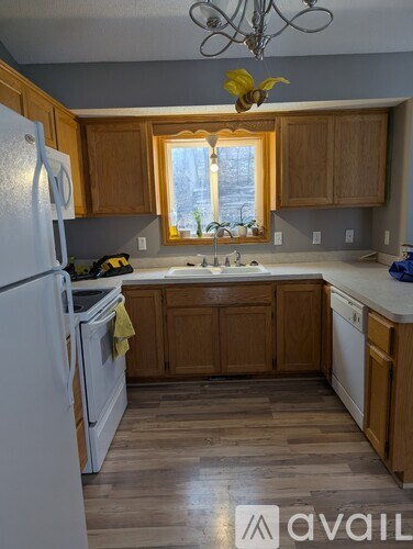 A kitchen with wooden cabinets and a white refrigerator.