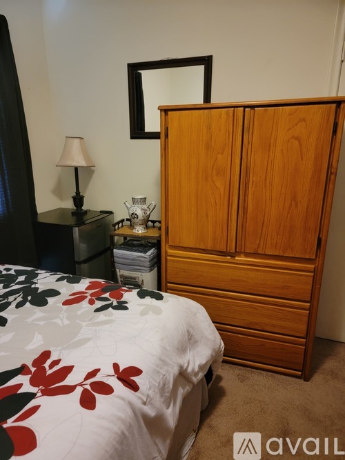 A bedroom with a bed, nightstand, and wardrobe.