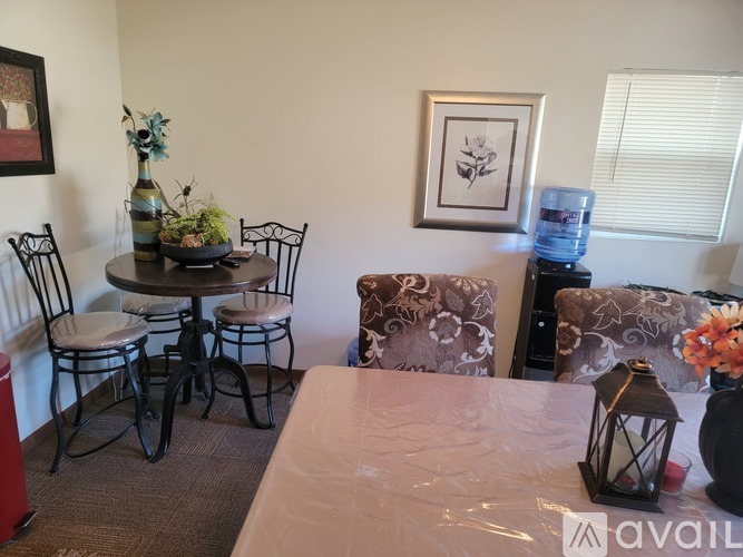 A living room with a couch, chair, table, and vase.